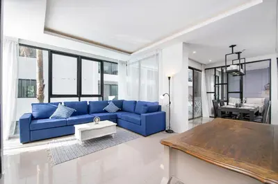 a living room with a blue couch and a table at 2bdr Apartment near Surin beach PALM-C302 in Surin Beach