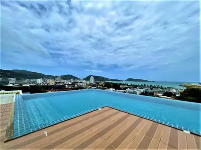 a swimming pool on the roof of a building with a view at Patong - The Unity Seaview & Mountain Residence in Patong Beach