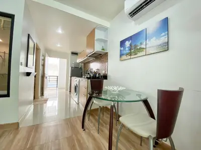 a kitchen and dining room with a glass table and chairs at Patong - The Unity Seaview & Mountain Residence in Patong Beach