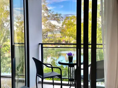 a room with a balcony with a table and chairs at Laguna cassia residences in Bang Tao Beach
