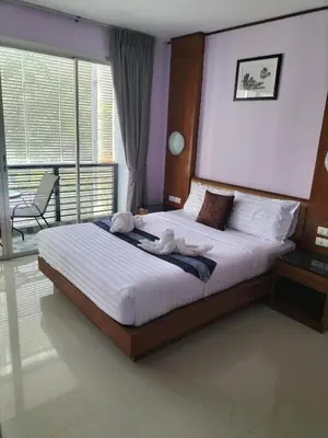 a bedroom with a large bed with two stuffed animals on it at La Piccola Kata in Kata Beach