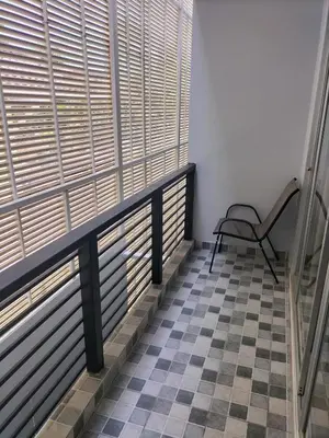 a balcony with a chair and a checkered floor at La Piccola Kata in Kata Beach