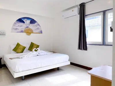 a white bedroom with a bed with a window at Remember at Phuket Town Hostel in Phuket Town