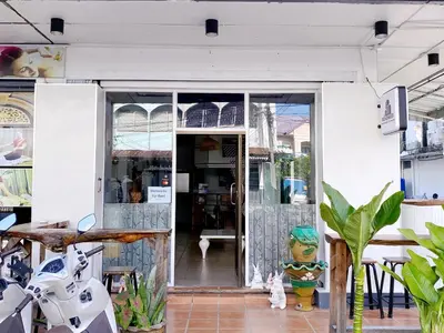 a glass door of a store with a cat sitting outside at Remember at Phuket Town Hostel in Phuket Town
