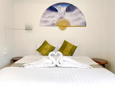 two swans are sitting on top of a bed at Remember at Phuket Town Hostel in Phuket Town