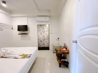 a white room with a bed and a television at Remember at Phuket Town Hostel in Phuket Town