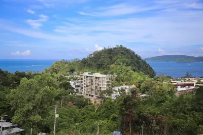 a building on top of a hill next to the ocean at Apartment in Aonang - great location with pool in Ao Nang Beach