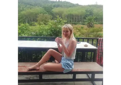 a young woman sitting on a bench on a table at Farm House kohyaoyai in Ko Yao Yai