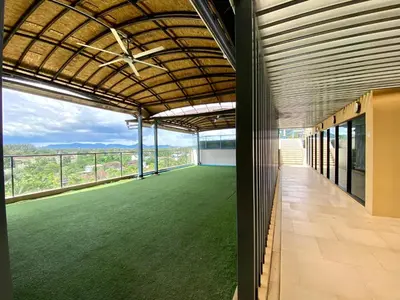 an empty building with a green lawn on the balcony at The aristo-access pool room Surin beach in Phuket Town