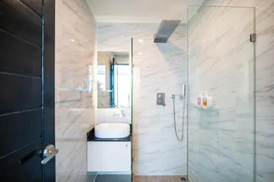 a bathroom with a shower with a sink and a toilet at Oceana Sea View - Kamala Beach in Kamala Beach