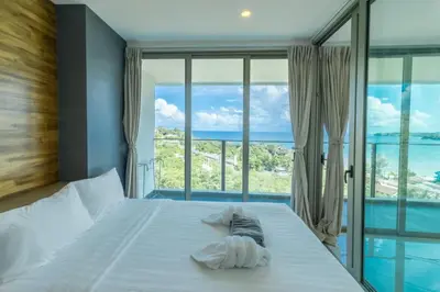 a bedroom with a bed with a view of the ocean at Oceana Sea View - Kamala Beach in Kamala Beach