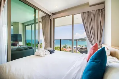 a bedroom with a large bed with a view of the ocean at Oceana Sea View - Kamala Beach in Kamala Beach