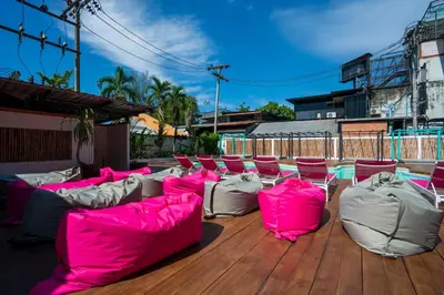 a deck with pink and white couches and chairs at Base Ao Nang Beachfront Party Hostel 18-35 Years Old Only in Ao Nang Beach