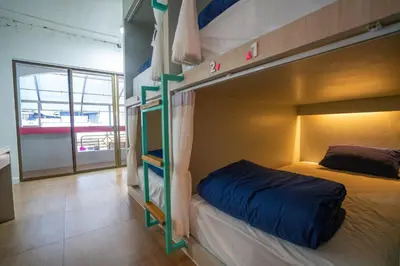 a bedroom with a bunk bed with a blue bedsheet at Base Ao Nang Beachfront Party Hostel 18-35 Years Old Only in Ao Nang Beach
