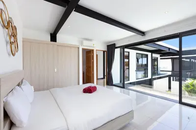 a bedroom with a white bed and a large window at Loft Style 4BR Villa Sunset Garden 4 with 12m Salt Water Pool, near NaiHarn in Rawai Beach