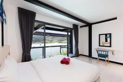 a bedroom with a white bed and a large window at Loft Style 4BR Villa Sunset Garden 4 with 12m Salt Water Pool, near NaiHarn in Rawai Beach