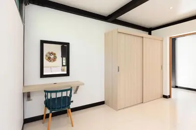 a room with a table and a chair and a door at Loft Style 4BR Villa Sunset Garden 4 with 12m Salt Water Pool, near NaiHarn in Rawai Beach