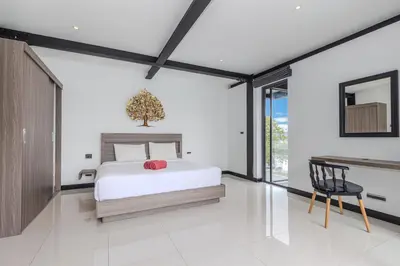 a bedroom with a bed and a table and a chair at Loft-Style Hyper Modern 4Br Villa Sunset garden 6 with 12x5m Salt Pool in Rawai Beach