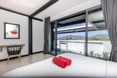 a bedroom with a bed and a large window at Loft-Style Hyper Modern 4Br Villa Sunset garden 6 with 12x5m Salt Pool in Rawai Beach