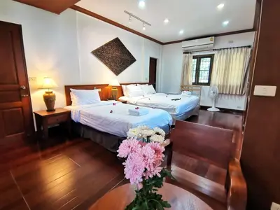 a hotel room with two beds and flowers in it at Kata Pool Villa ​No.7 in Kata Beach