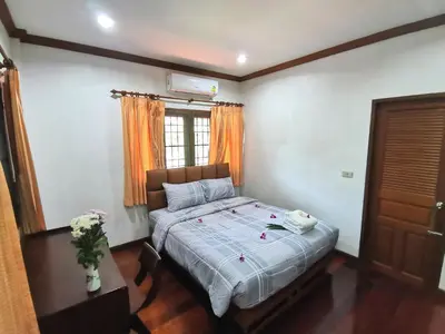 a bedroom with a bed and a window at Kata Pool Villa ​No.7 in Kata Beach