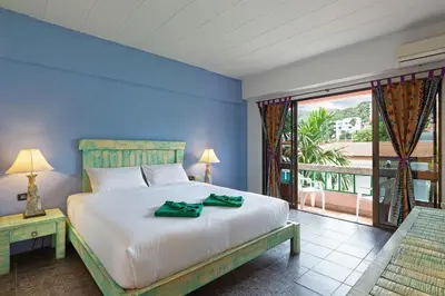 a bedroom with a large bed and a large window at Casa Brazil Homestay in Karon Beach