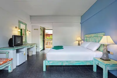 a bedroom with a white bed and a tv at Casa Brazil Homestay in Karon Beach