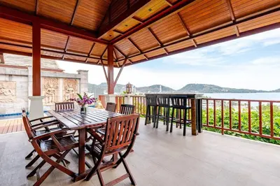a patio with a table and chairs on a balcony at Patong Seaview Luxury Villa Penda in Patong Beach
