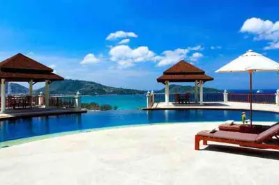 a resort swimming pool with a view of the water at Patong Seaview Luxury Villa Penda in Patong Beach