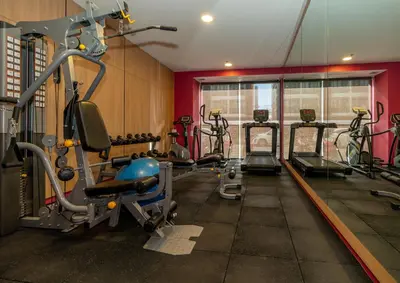 a gym with several tread machines in a room at GLOW Mira Karon Beach in Karon Beach