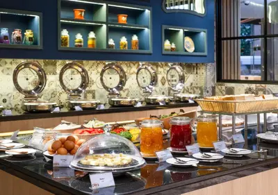 a buffet of food on a counter in a restaurant at GLOW Mira Karon Beach in Karon Beach