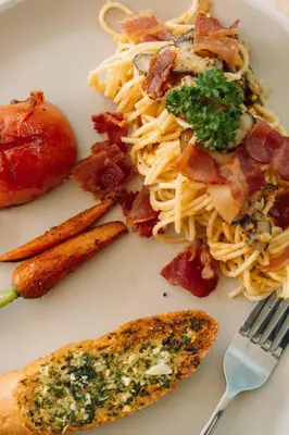 a plate of food with pasta and meat and a fork at The Pin Boutique Pool Villa Krabi in Ao Nang Beach