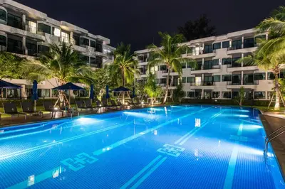 a swimming pool in front of a hotel at night at Holiday Style Ao Nang Beach Resort, Krabi in Ao Nang Beach