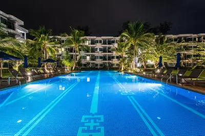 a swimming pool in front of a hotel at night at Holiday Style Ao Nang Beach Resort, Krabi in Ao Nang Beach
