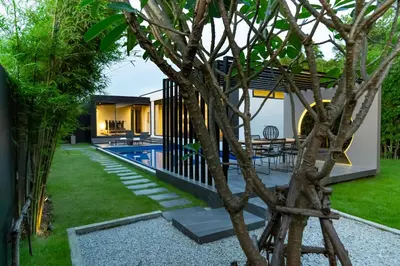 a modern house with a swimming pool and a tree at Villoft Zen Living Resort in Thalang