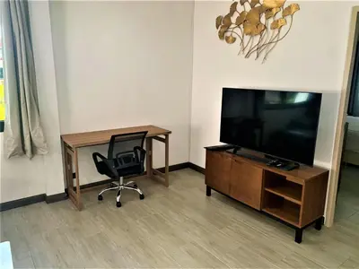 a living room with a television and a chair at Kamala Fantasy 5 Bedroom Modern Private Pool Villa in Kamala Beach