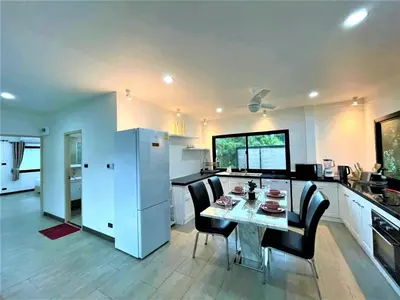 a kitchen and dining room with a table and chairs at Kamala Fantasy 5 Bedroom Modern Private Pool Villa in Kamala Beach