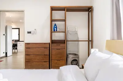 a bedroom with a bed and a wooden closet at Kamala Fantasy 5 Bedroom Modern Private Pool Villa in Kamala Beach