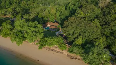 an overhead view of a beach with a house and trees at Touch Beachfront Pool Villa Koh Yao Noi in Ko Yao Noi