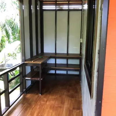 a wooden bench in a room with a window at Lok Mun Bungalows in Ko Yao Noi