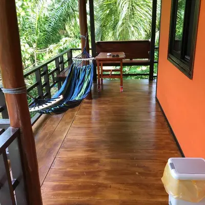 a hammock on the porch of a house at Lok Mun Bungalows in Ko Yao Noi