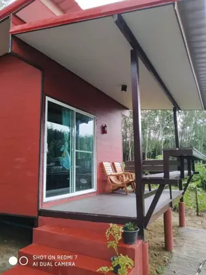 a red cabin with a porch and a picnic table at Lok Mun Bungalows in Ko Yao Noi