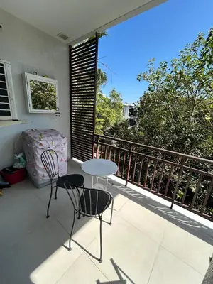a patio with two chairs and a table on a balcony at The Title Rawai Beach West Wing by EHM in Rawai Beach