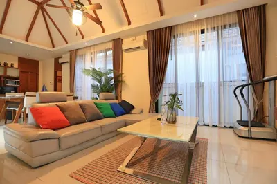 a living room with a couch with colorful pillows on it at 3bedroom pool villa only 250m to the Rawai beach F10 in Phuket Town