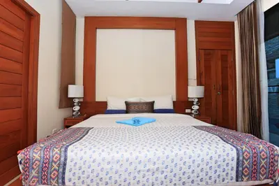 a bedroom with a bed with a blue tray on it at 3bedroom pool villa only 250m to the Rawai beach F10 in Phuket Town