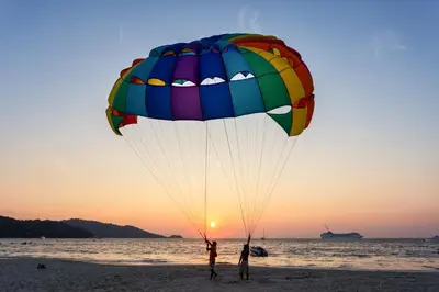 a person flying a parachute on the beach at Add Plus Hotel & SPA in Patong Beach