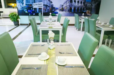 a dining room with white tables and green chairs at Add Plus Hotel & SPA in Patong Beach