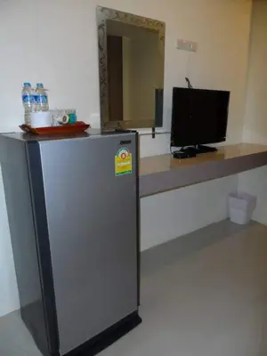 a refrigerator in a room with a desk with a television at Life&Love Resort in Ban Khlong Son