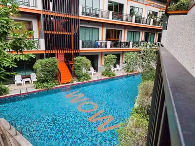 a swimming pool in front of a building at WOW PHUKET in Phuket Town