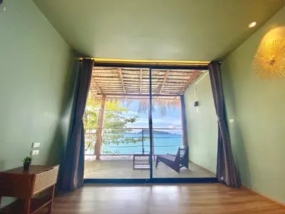 a room with a sliding glass door with a view of the ocean at patong sunset villa Phuket in Patong Beach